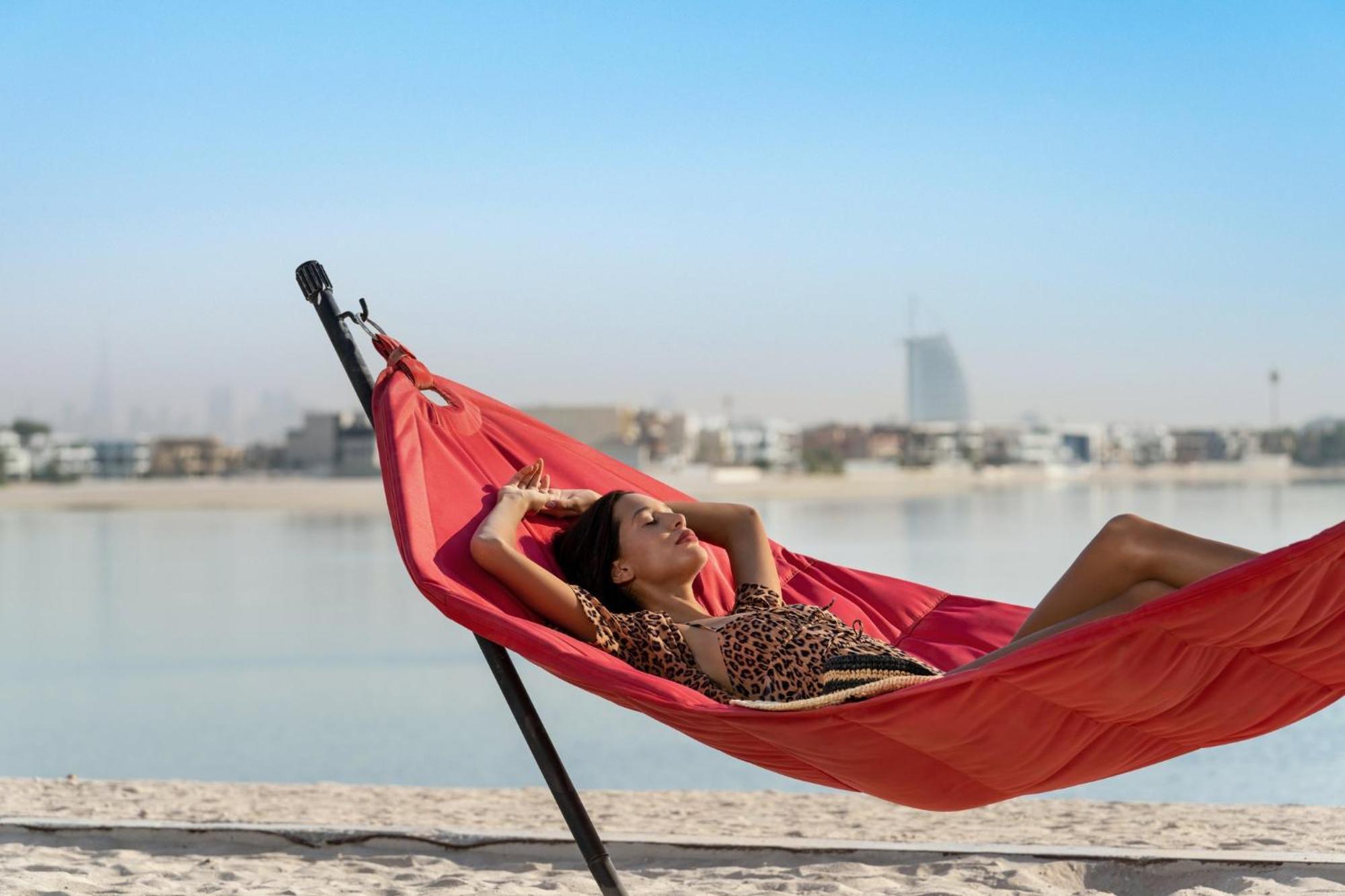 Th8 Palm Dubai Beach Resort, Vignette Collection By Ihg Eksteriør billede A woman relaxing in a hammock